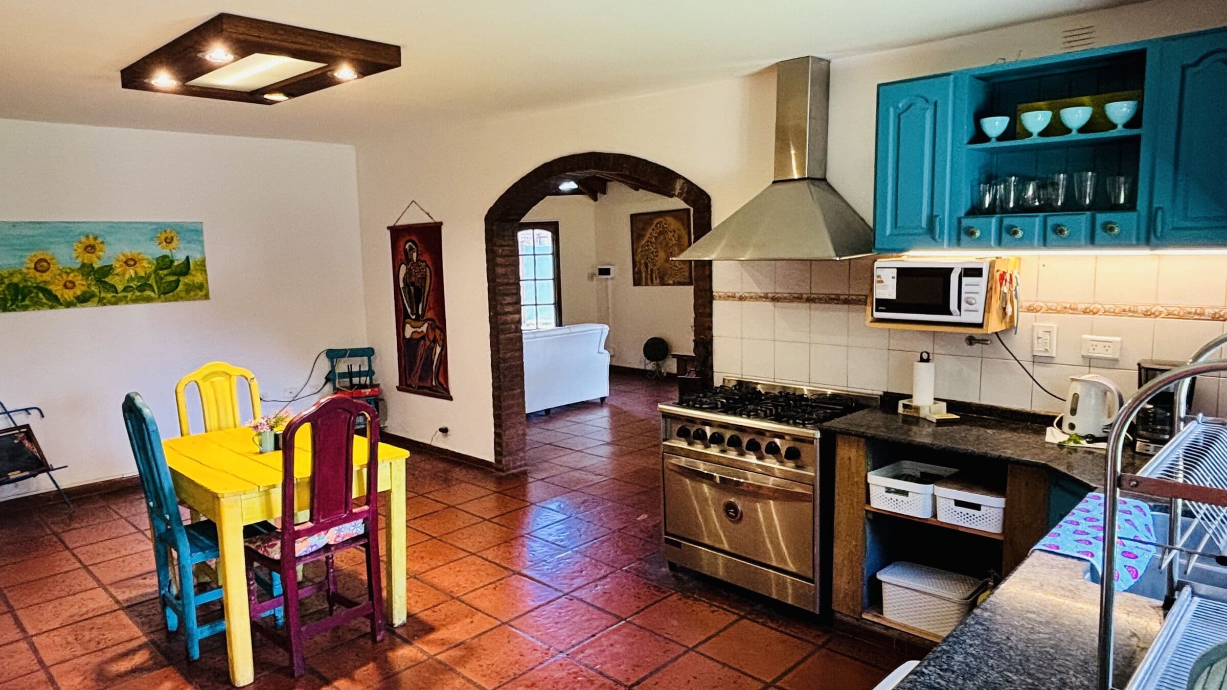 Cocina amplia con mesa amarilla y sillas de colores