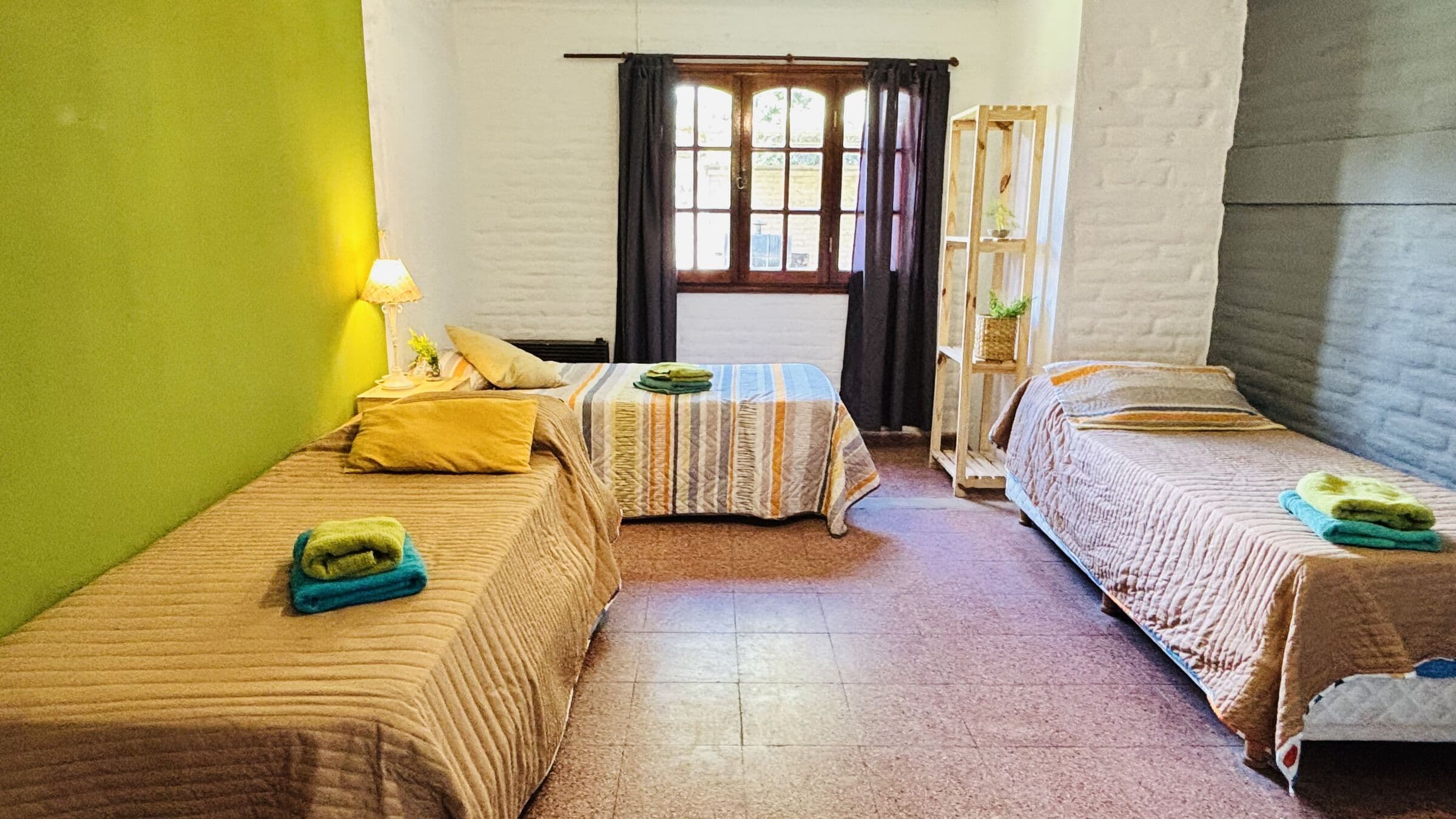 Dormitorio verde con tres camas individuales